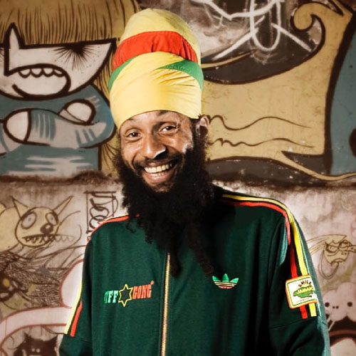 A bearded man in a green tracksuit and a yellow red and green turban