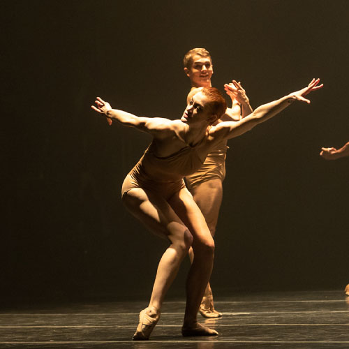 Dancers performing on a dimly lit stage