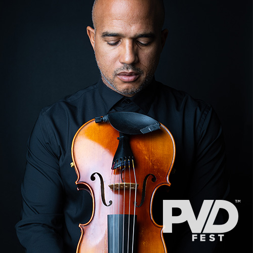 A Black man looking down the upside down body of a violin