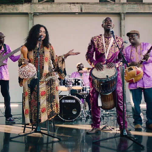 Un grupo de músicos con coloridas ropas africanas tocando música