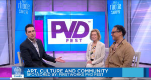 A woman and two men seated in a TV studio with a PVDFest logo showing on a screen behind them